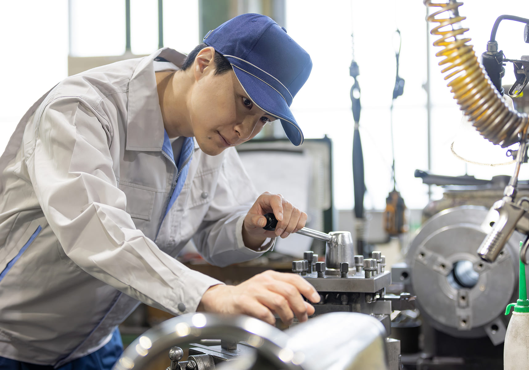 作業着の男性が設備機械を動かしている様子